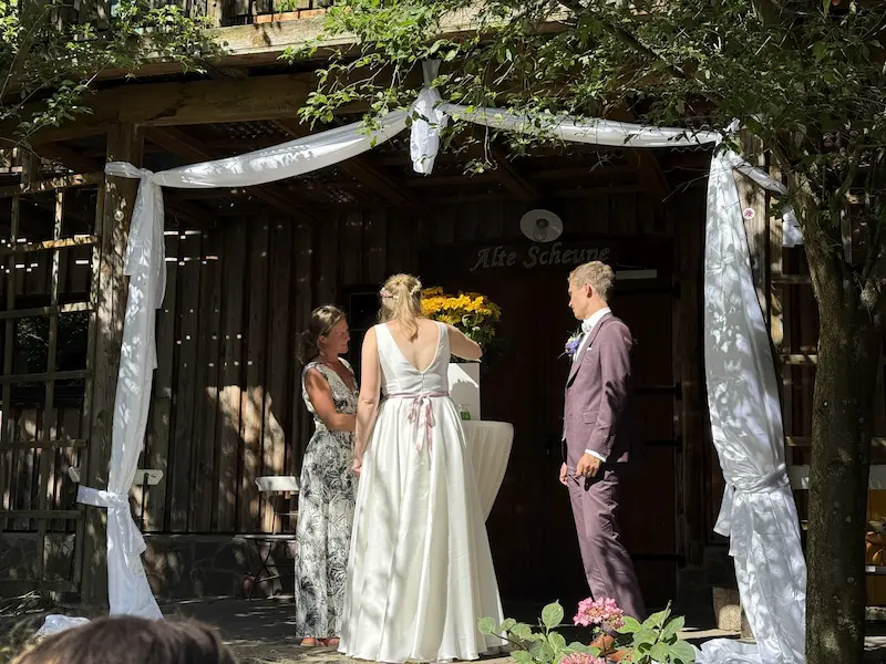 Kreatives Trauritual: Brautpaar gießt bunte Acrylfarben über eine Leinwand.