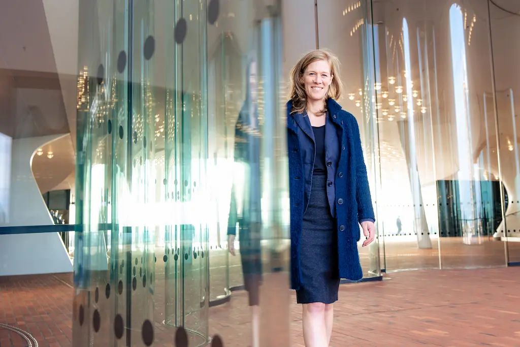 Keynote Speakerin Ann-Sophie Schammer auf dem Weg zur Bühne in einem modernen Unternehmensgebäude.