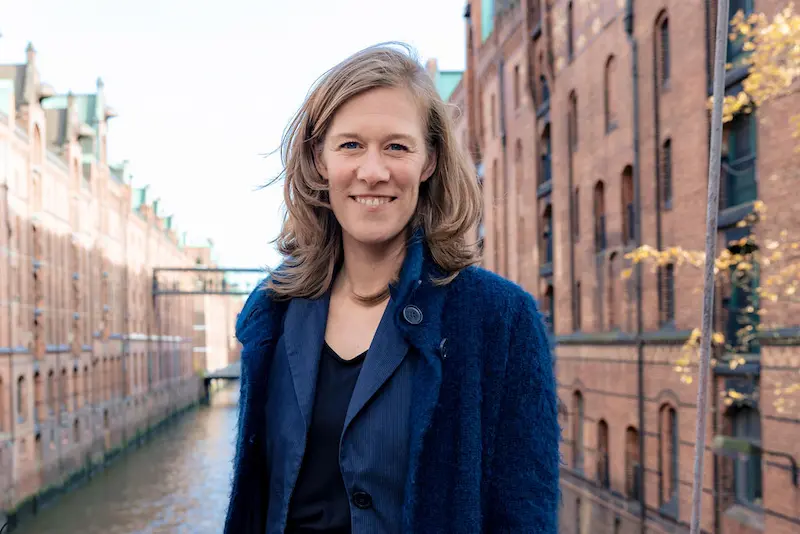 Ann-Sophie Schammer, Freie Rednerin und Moderatorin Hamburg, im Business-Portrait vor Kontoren aus dem Hamburger Hafen.