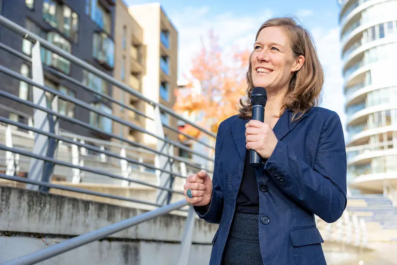 Ann-Sophie Schammer moderiert ein Kick-Off Event: Energiegeladene Ansprache mit Mikrofon.